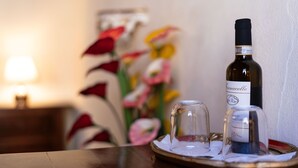 A bottle of wine on a tray with a glass and a candle. - [Old Town] Elegant Suite, Wi-fi & Comfort (San Gimignano)