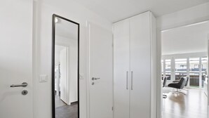 A modern hallway with white doors, a large mirror, and a wardrobe. - Nr.78 Haus Ladina by Interhome (Lenzerheide)