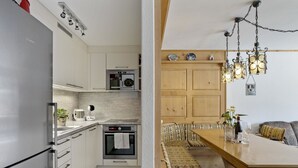 A modern kitchen with stainless steel appliances, a wooden dining table, and a patterned rug. - Nr.58 Haus Ladina by Interhome (Lenzerheide)