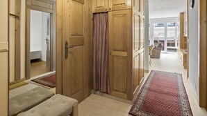 A hallway with wooden cabinets, a bench, and a red patterned rug. - Nr.58 Haus Ladina by Interhome (Lenzerheide)
