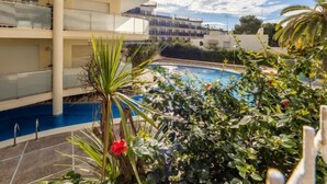 Un edificio moderno con una piscina immersa nel verde e palme.