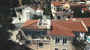 A residential area with terracotta-tiled roofs, white buildings, and a small church with a bell tower. - In the shadow of Acropolis - Breathtaking view  (ATHENS)