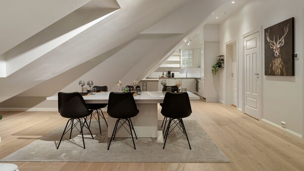 A modern dining area with a central island, black chairs, and a light-colored rug. - ARCTIC HOMES - THE RETREAT (Tromsø)