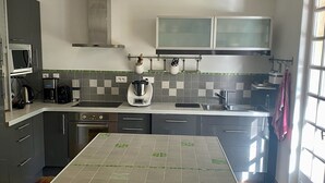 Una cocina moderna con armarios grises, una isla grande, un microondas y una cafetera.