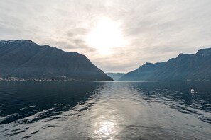 A calm lake surrounded by mountains with a clear sky.