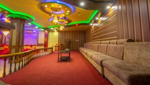 Un théâtre doté d’un tapis rouge, de sièges confortables et d’une rambarde en bois.
