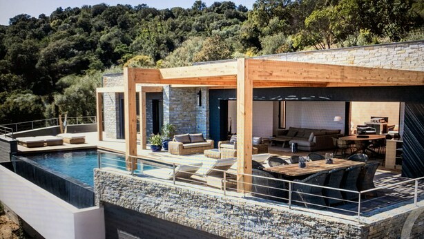 A modern house with a swimming pool, outdoor seating, and a stone facade. - porto vechio saint cyprien (zonza)