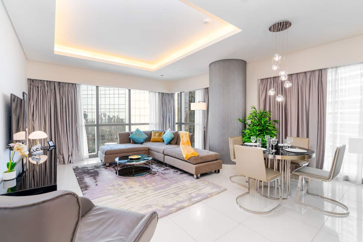 A modern living room with a sofa, coffee table, and dining area.