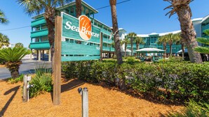 Un letrero de hotel con 'Sea Breeze' y un edificio de varios pisos y balcones.