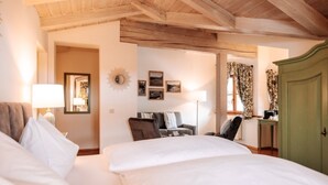 A hotel room with two beds, a desk, a chair, and a wardrobe. - Geniesserhotel Hubertus (Filzmoos)