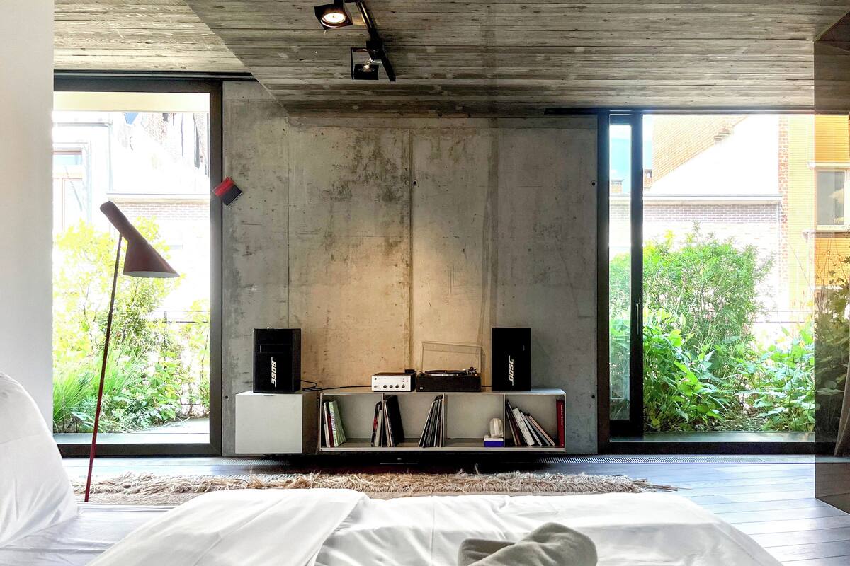 Ein modernes Schlafzimmer mit einem großen Bett, einem Flachbildfernseher und einem Bücherregal.