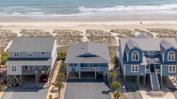 Una propiedad frente al mar con una casa grande, una casa más pequeña y un garaje.