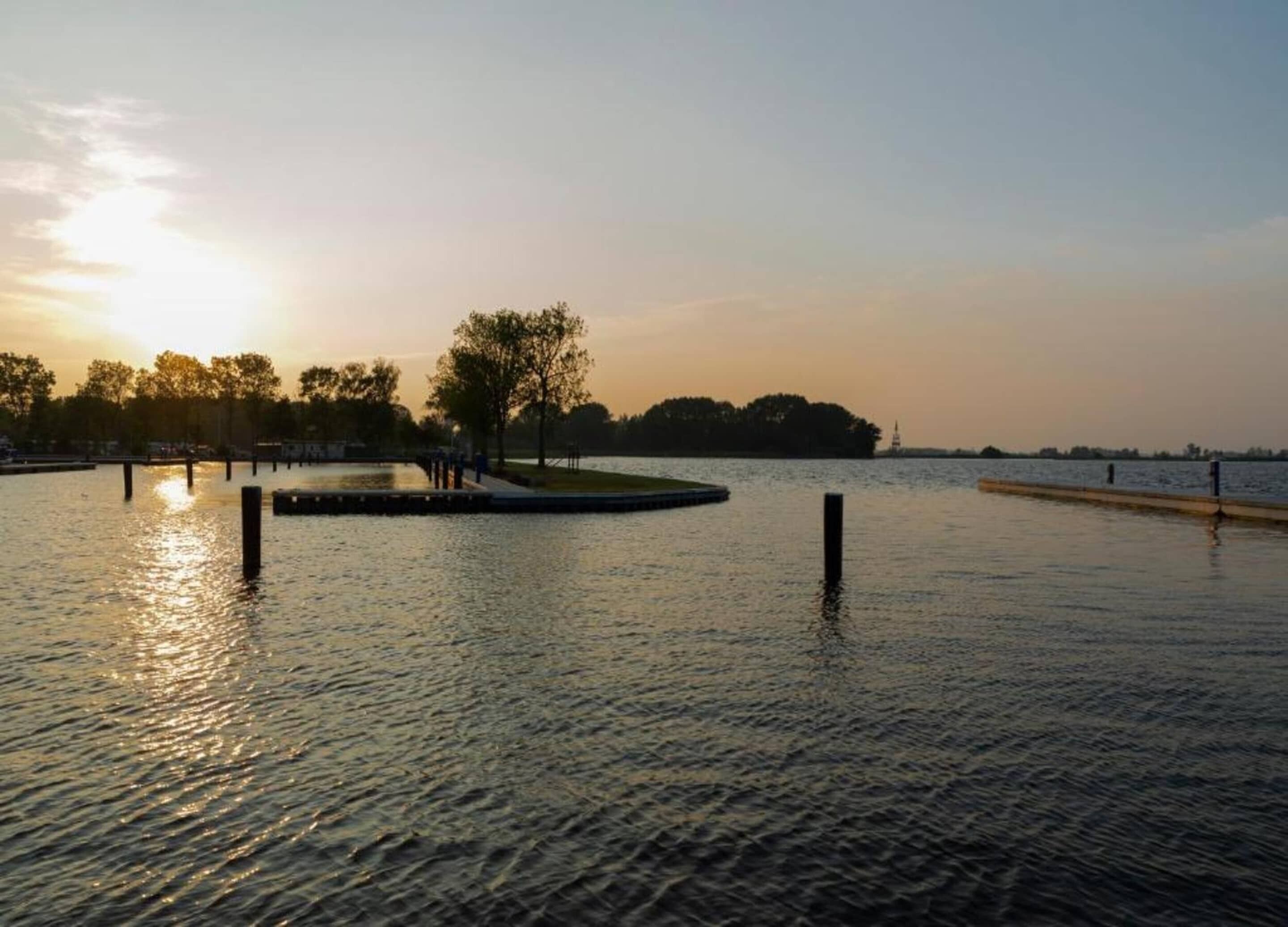 A calm water body with a dock and trees, likely a park or marina.