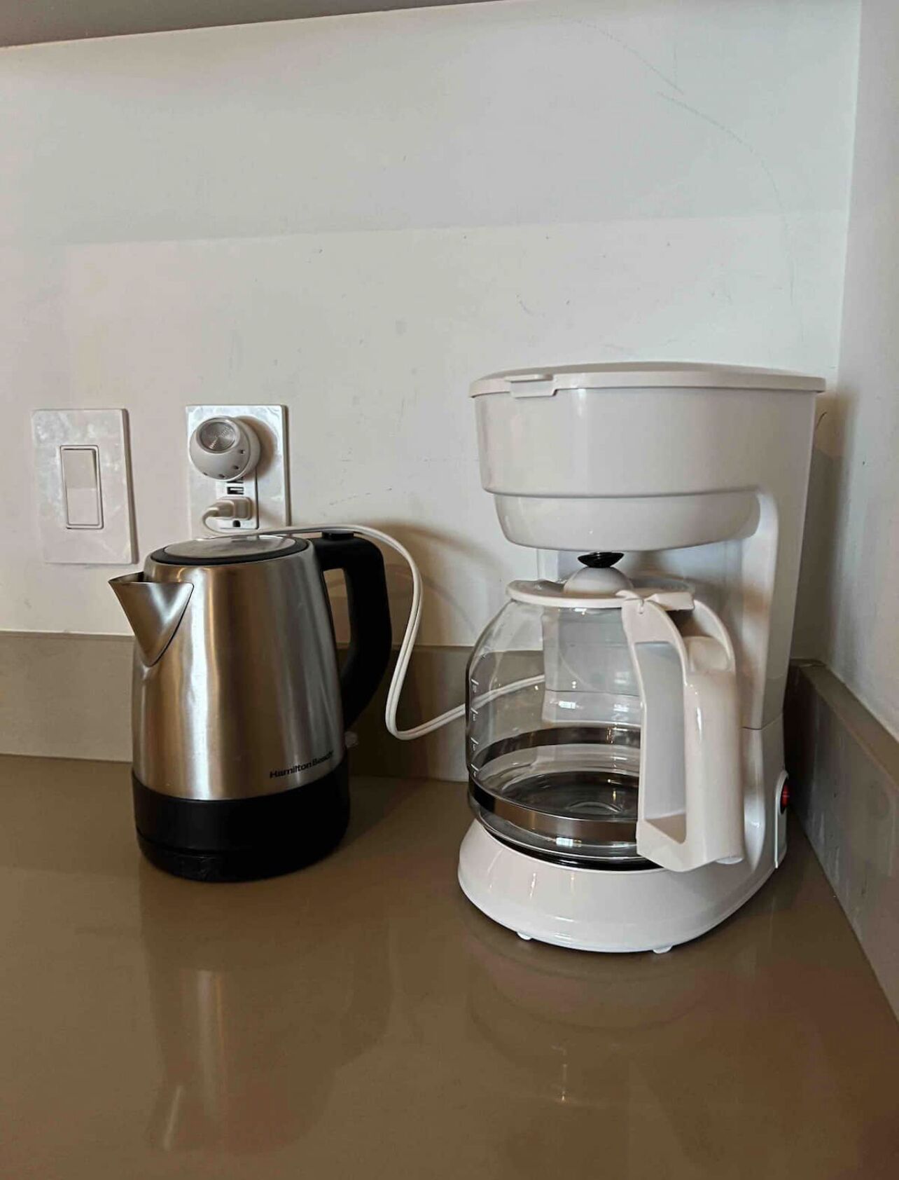 A coffee maker and a kettle on a kitchen counter.
