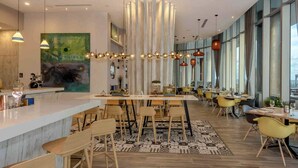 A modern restaurant with a central bar, high ceilings, and large windows. - Cozy unit @ 18th Floor with Ocean view (Hollywood)