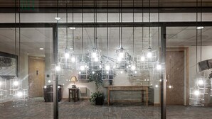 Ein modernes Interieur mit hängenden Pendelleuchten, einer Holzbank und einem Blumentopf.