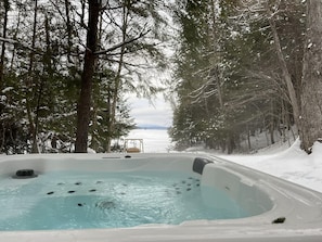 A hot tub surrounded by snow-covered trees and a snowy landscape.