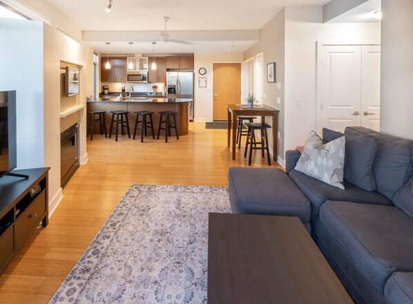 A modern living room with a gray sofa, a coffee table, and a patterned rug. - Mt. Tolmie View-Spacious, Bright NE Facing Two Bedroom Condo with Den by Victoria Prime! (Victoria)