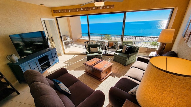A living room with a television, sofas, a coffee table, and a view of the ocean. - Sonoran Spa E603 - 2 BR Next to the Pool, High Speed Wi-Fi - Beachfront Upper Floor Luxury Condo (Puerto Peñasco)