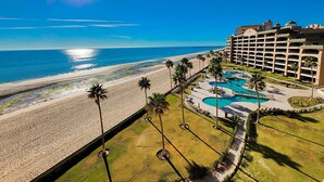A hotel with a pool area, beach access, and a view of the ocean. - Sonoran Spa E603 - 2 BR Next to the Pool, High Speed Wi-Fi - Beachfront Upper Floor Luxury Condo (Puerto Peñasco)