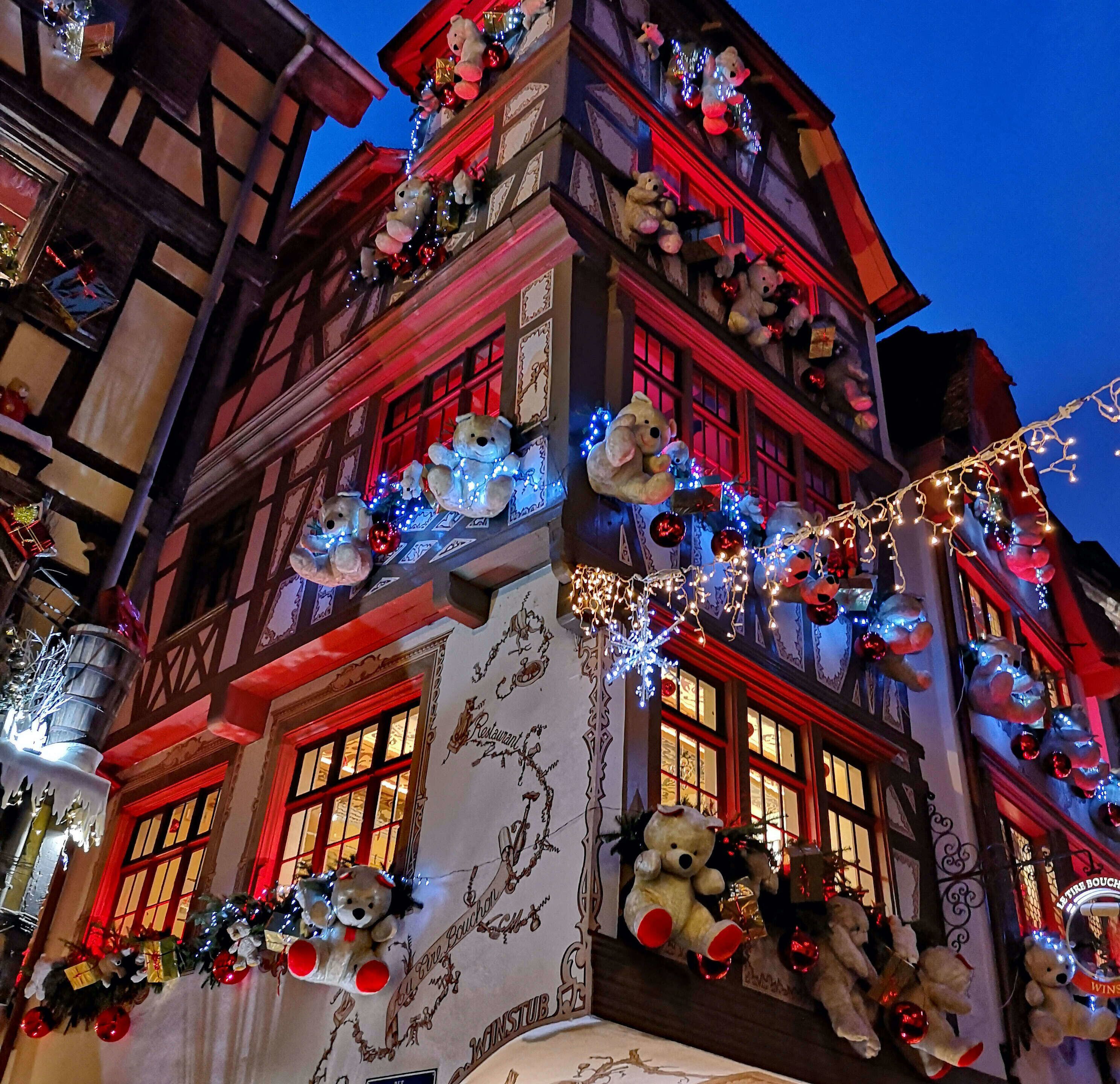 Ein mehrstöckiges Gebäude, geschmückt mit vielen Teddybären und Weihnachtsbeleuchtung.