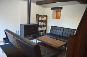 A living room with a sofa, a wooden coffee table, a bookshelf, and a fireplace.