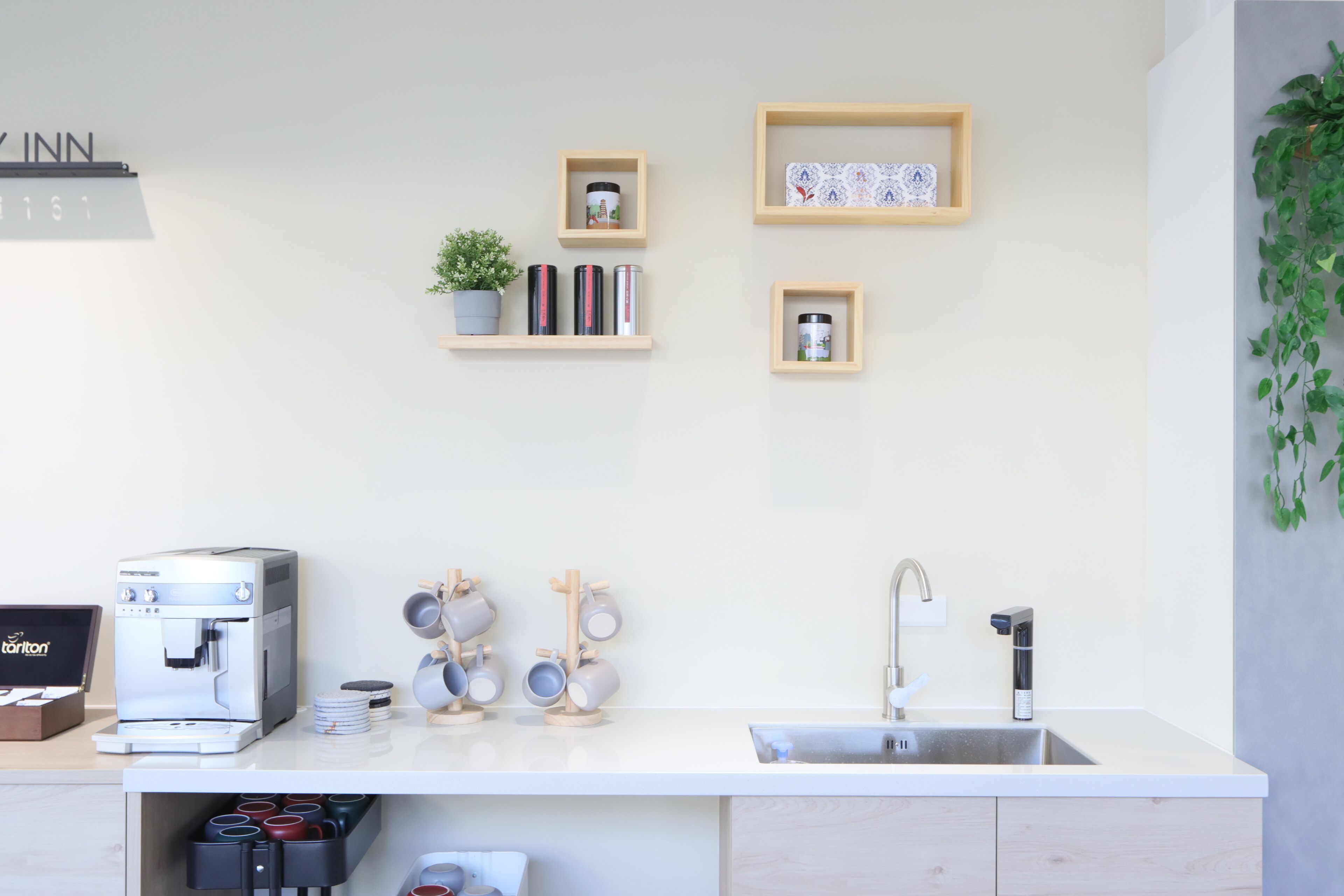 Eine moderne Küche mit Kaffeemaschine, Tassen und Spüle.