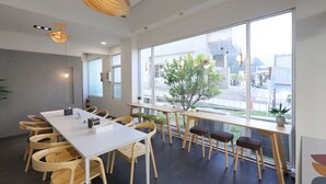 A modern meeting room with a white table, wooden chairs, and large windows offering a view of the city. - EasyInn (Yuchi)