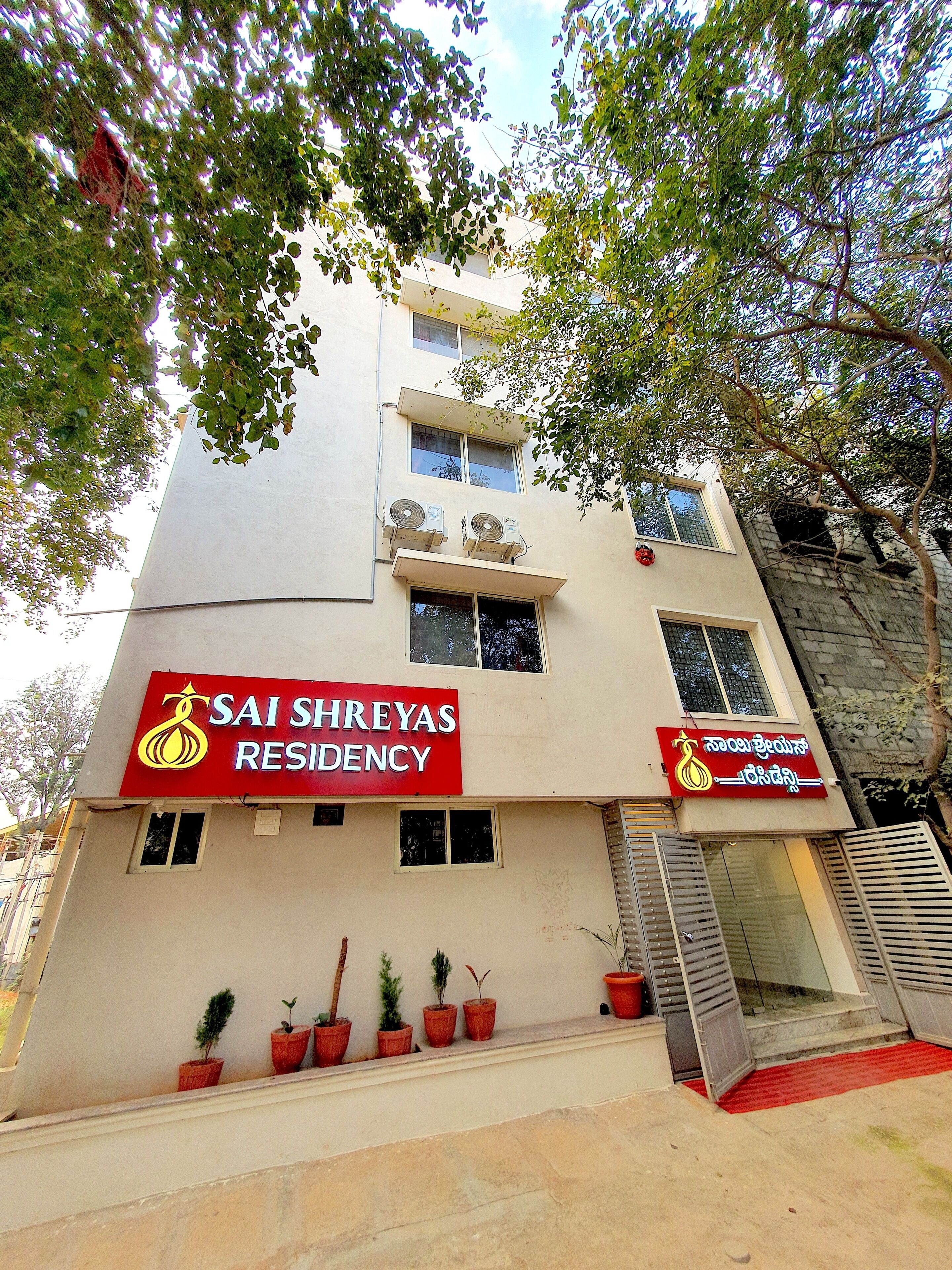En byggnad med en skylt som visar texten "SAI SHREYAS RESIDENCY".