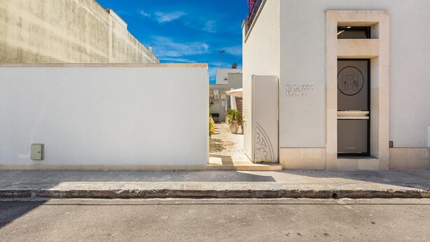 Une rue étroite avec l’entrée d’un immeuble portant l’inscription « PALAZZO FLORA ».