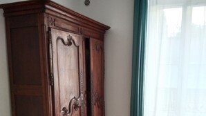 A room with a wooden wardrobe, a radiator, and a window with a curtain. - Andrea apartment (Fontenay-sous-Bois)