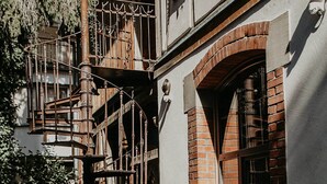 A building with a brick facade, a wooden spiral staircase, and a cactus plant. - "La Bohème" Chic & Unique Designer Loft in Alsace (Guebwiller)
