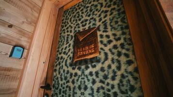 Una porta di legno con tessuto a stampa leopardo e un cartello con la scritta "UN AILE DE SAVANE".