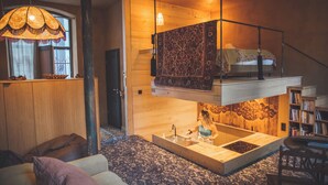 Une pièce chaleureuse avec un lit en mezzanine, un évier intégré et un plancher en bois.