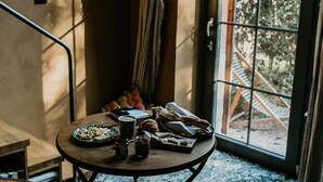 Une pièce avec une table ronde, une chaise, une tasse de café et des pâtisseries.