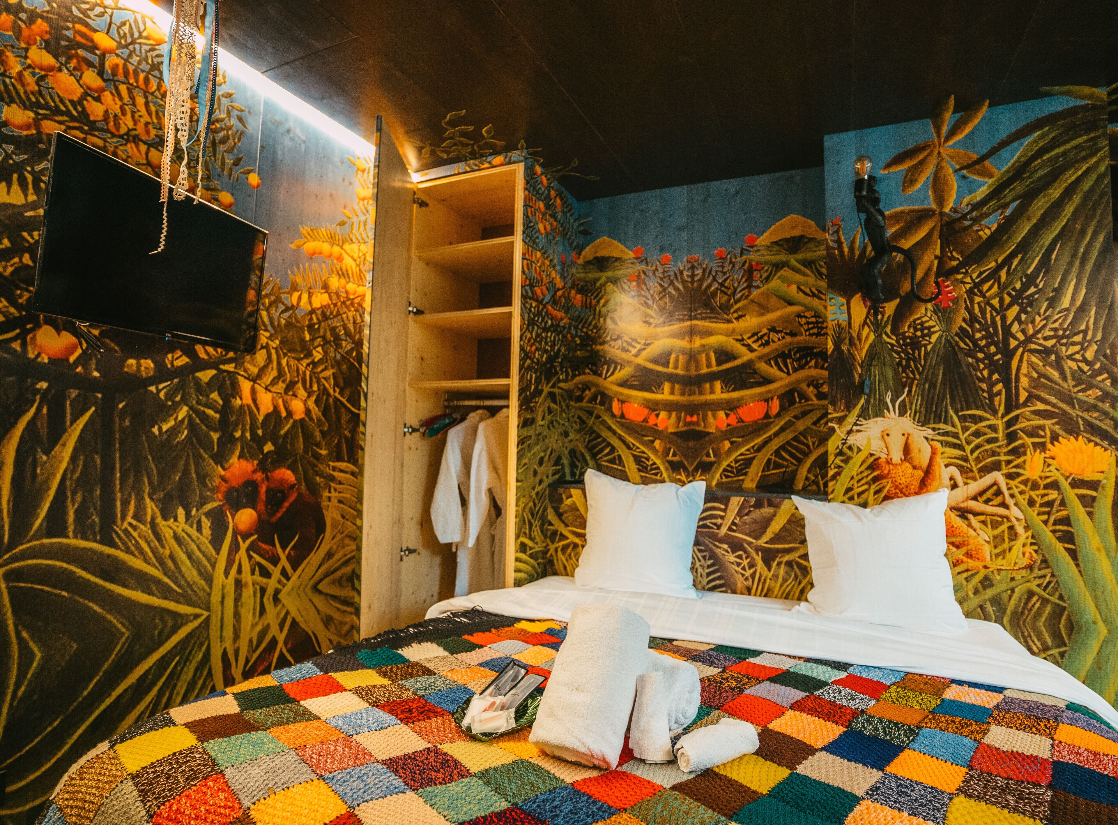 Ein Zimmer mit einem Bett, einem Kleiderschrank und einem Wandgemälde.