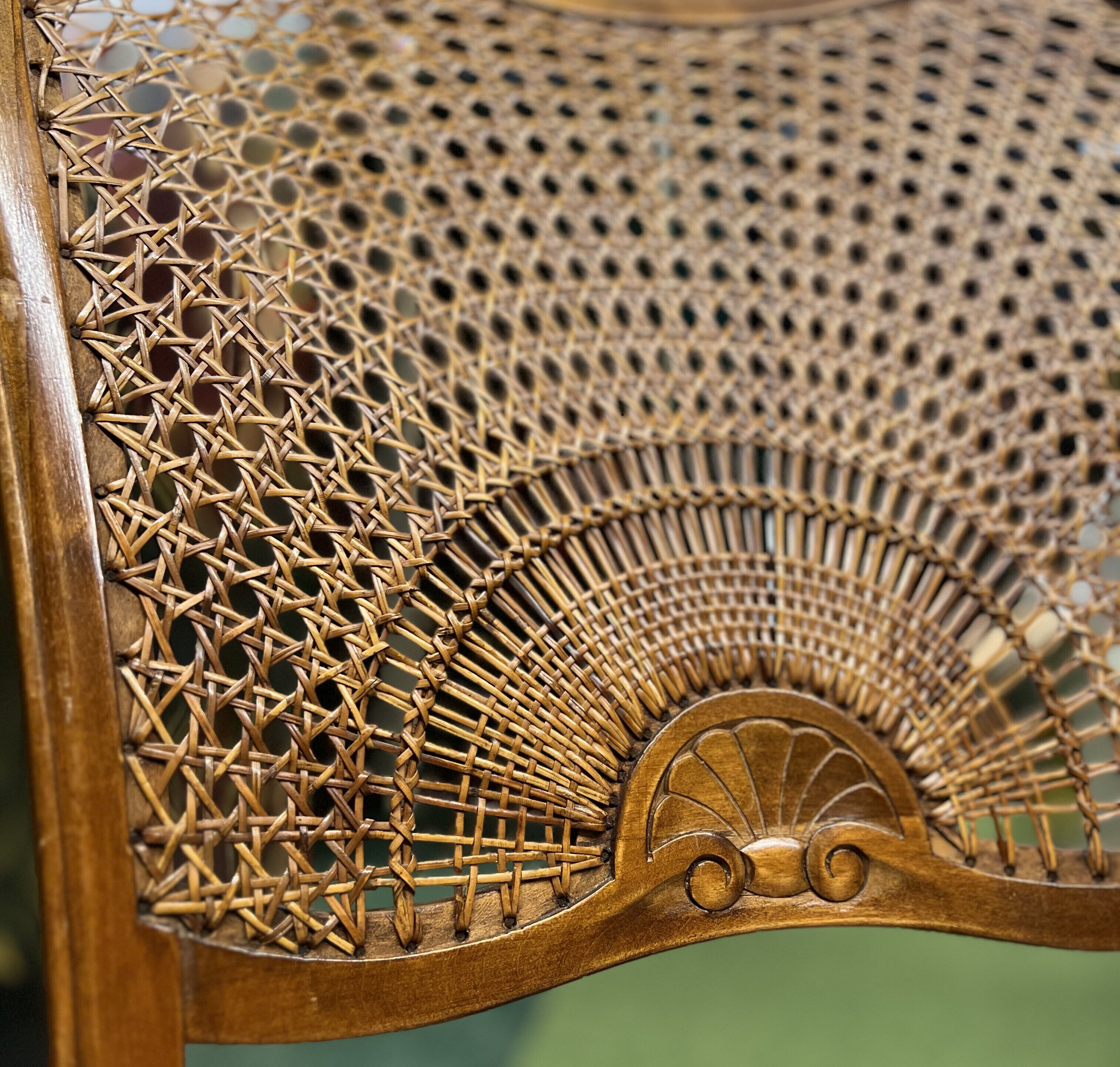 Primer plano de una silla de mimbre con un intrincado diseño tejido y un respaldo curvo.