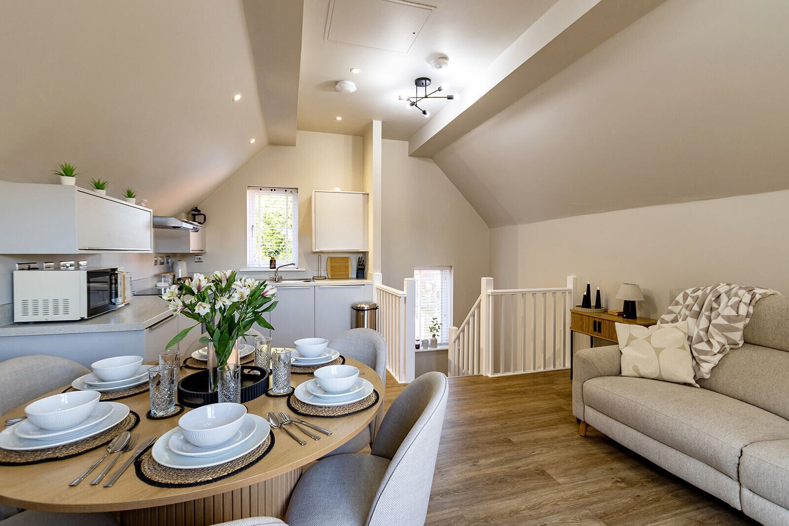 A modern loft-style living space with a dining area, kitchen, and a cozy seating area.