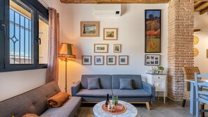 A living room with a sofa, a coffee table, and a brick wall. - Country House 'La Criba - Casa Rural Eralta' with Mountain View, Wi-Fi and Air Conditioning (Dúrcal)