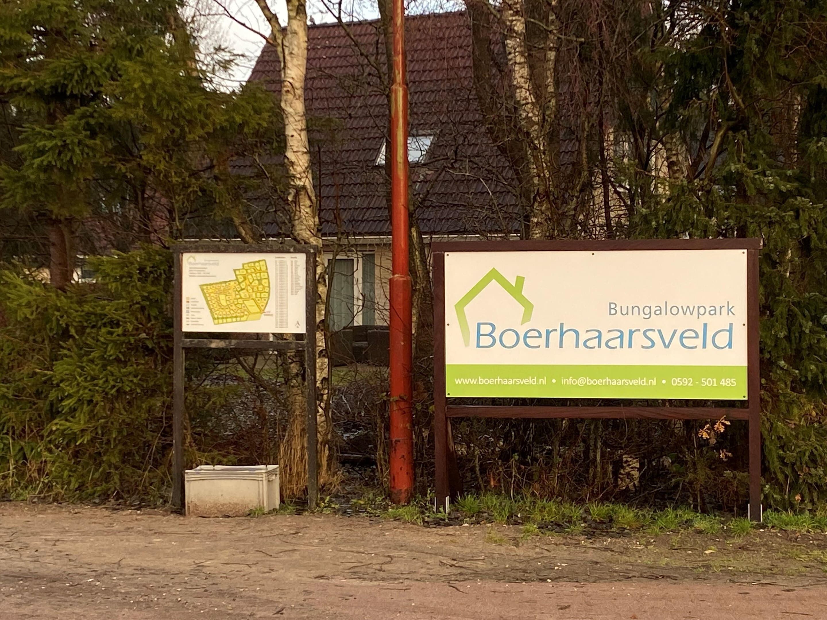 Un cartel para Boerhaarsveld Bungalowpark con información de contacto y una dirección web.
