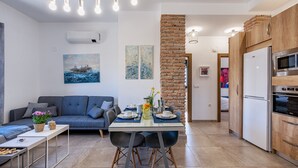 Une cuisine moderne avec un coin repas, un canapé et des œuvres d’art accrochées aux murs.