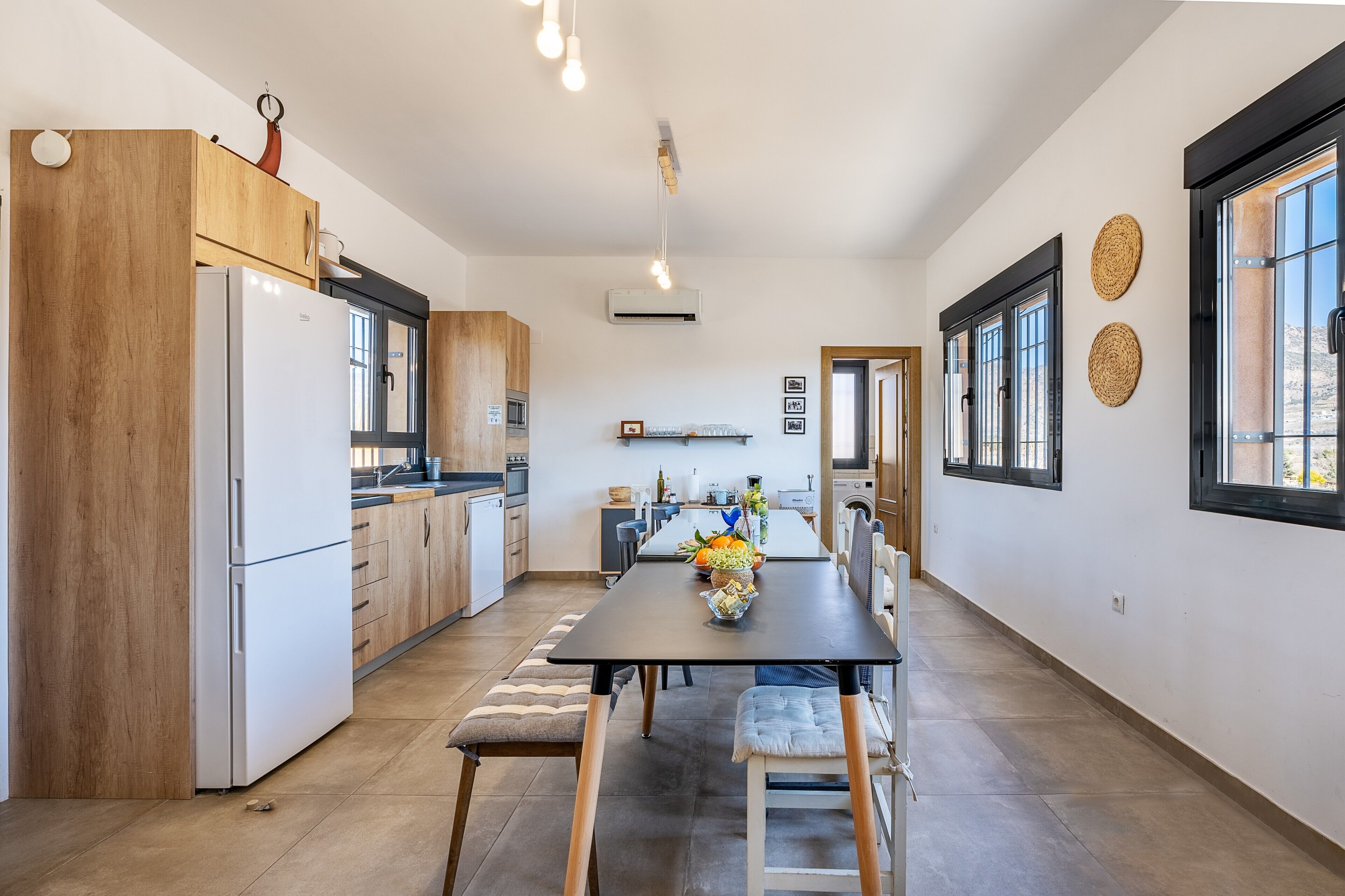 Una cucina moderna con mobili in legno, un frigorifero bianco e un tavolo da pranzo con sedie.