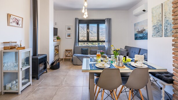 Un salon moderne comprenant un coin repas, une cheminée et une grande fenêtre offrant une vue dégagée.