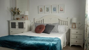 A bedroom with a bed, a nightstand, a dresser, and a mirror. - Country House "Eralta" with Mountain View, Private Pool & Wi-Fi (Dúrcal)
