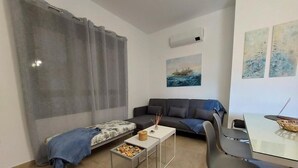 A modern living room with a sofa, a coffee table, and a dining table. - Country House "Eralta" with Mountain View, Private Pool & Wi-Fi (Dúrcal)