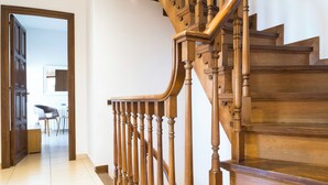 Una escalera de madera con barandilla que lleva a un piso superior.