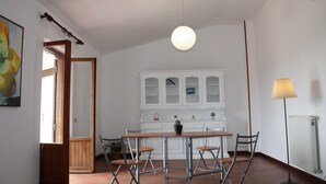 A room with a dining table, chairs, a hanging light fixture, a cabinet, and a radiator. - Comfortable apartment in nature (FREE PARKING)-just a stone's throw from the park (Castel di Leva)
