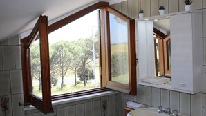 A bathroom with a large window, a sink, and a mirror. - Comfortable apartment in nature (FREE PARKING)-just a stone's throw from the park (Castel di Leva)