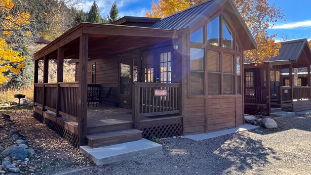 Eine rustikale Holzhütte mit Veranda, großen Fenstern und einem Schild mit der Nummer 42.