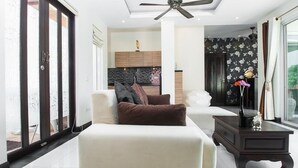 A modern living room with a sofa, a coffee table, and a ceiling fan. - Most beautiful Penthouse! (Muang Pattaya)